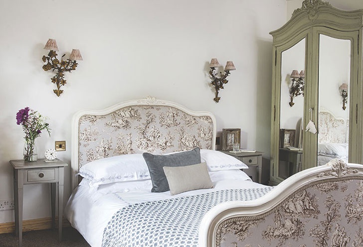 Galvenajā guļamistabā franču gulta ir skaisti pārklāta ar audumu