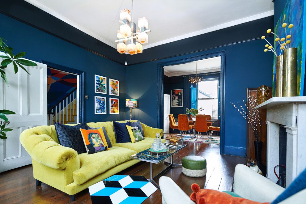 Dzeltens dīvāns ar tumši ziliem spilveniem