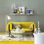 Dzeltens dīvāns pelēkā interjerā